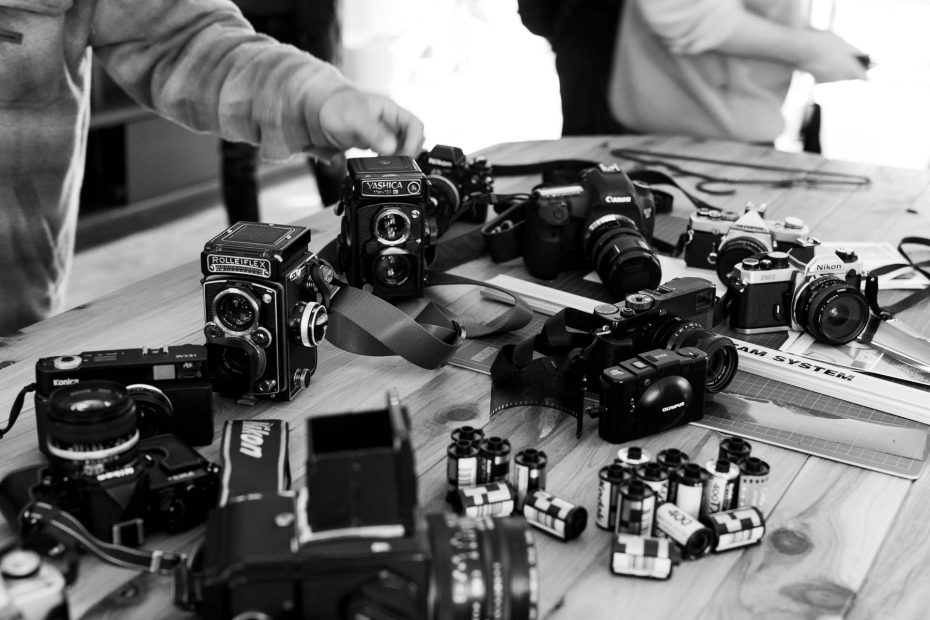 a huge range of film cameras placed on a desktop after a group photo walk in olinda